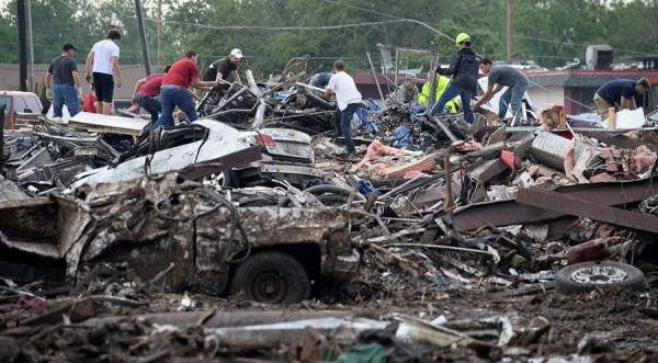 Rescuers search through rubble after a tornado struck Moore, Oklahoma, May 20, 2013. A 2-mile-wide (3-km-wide) tornado tore through the Oklahoma City suburb of Moore on Monday, killing at least 51 people while destroying entire tracts of homes, piling cars atop one another, and trapping two dozen school children beneath rubble. REUTERS/Gene Blevins (UNITED STATES - Tags: ENVIRONMENT DISASTER)