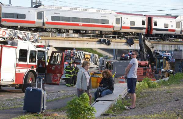 Passengers wait to be picked-up after two commuter trains collided in Bridgeport