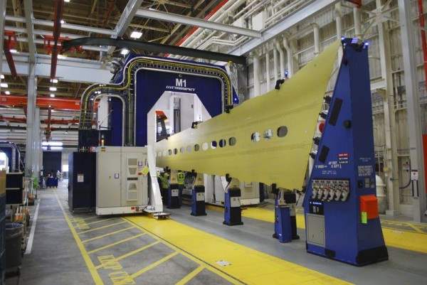 Синяя, в форме подковы сборочная машина скользит по желтой панели крыла, которая станет частью 737 лайнера, на заводе Boeing в городе Рентон, штат Вашингтон. Снимок 12 марта 2015 года 