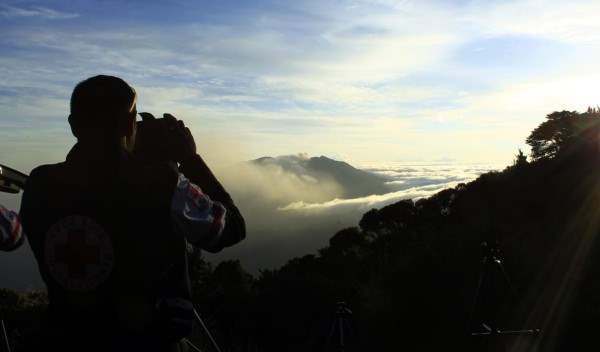 A red cross worker takes a photo of Turrialba volcano, from San Gerardo de Irazu near Turrialba