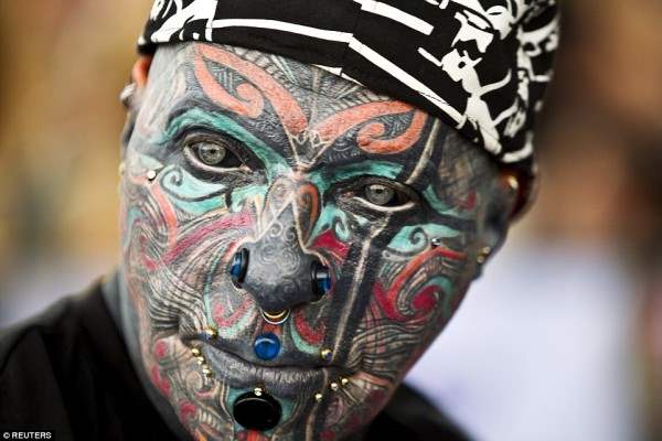 Немецкий тату модель Магнето - чье все лицо, в том числе глазные яблоки покрыты чернилами - позирует для камеры в Тель-Авиве