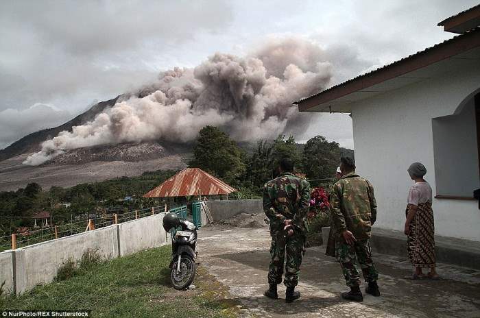 Беспомощные: Военнослужащие в Тига Серангкай Вилладж смотрят, как Синабунг продолжает извергаться. 