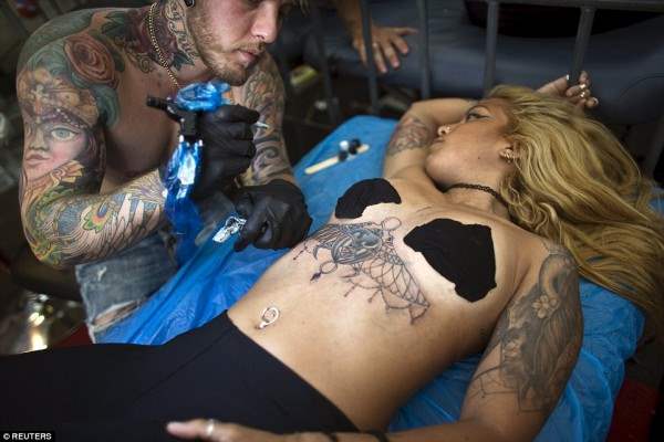 Женщина обнажилась, чтобы мастер смог нанести новое тату на ее тело.