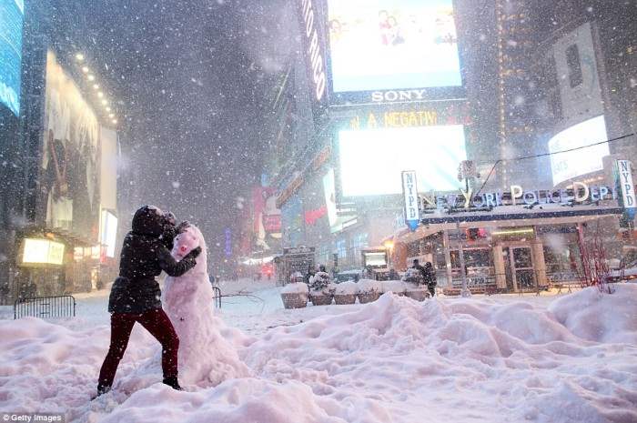 Таймс-сквер, Нью-Йорк. Женщина лепит снеговика.