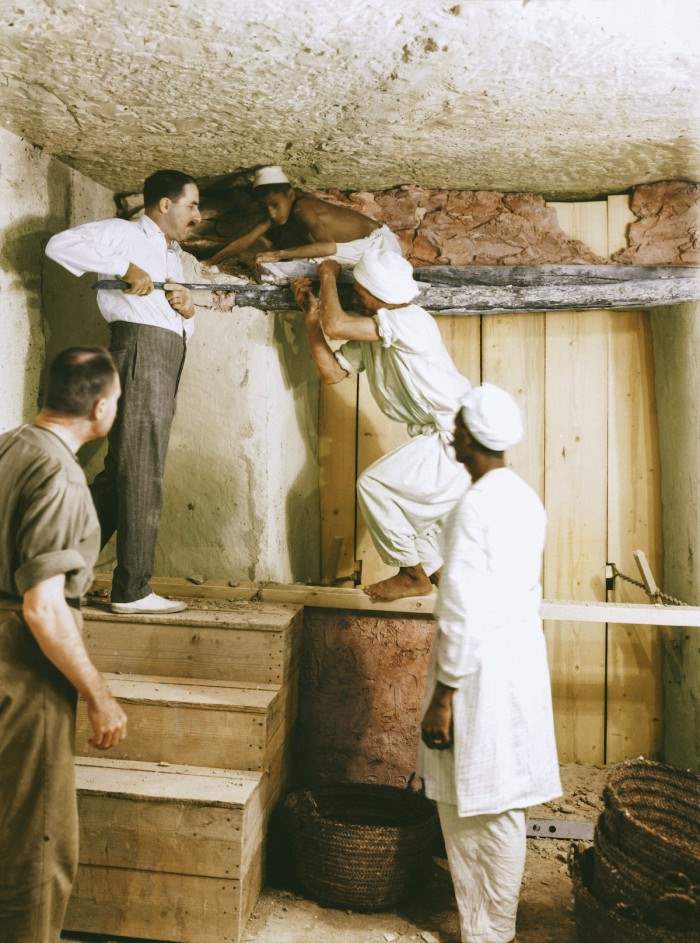 2 декабря 1933. Говард Картер (на верху лестницы), Артур Каллендер и египетские рабочие удаляют стены между прихожей и погребальной камерой, чтобы сделать демонтаж четырех золотых святынь, вмещающих саркофаг.