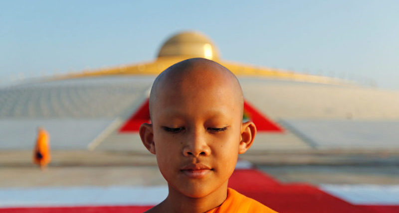Буддист молится в храме