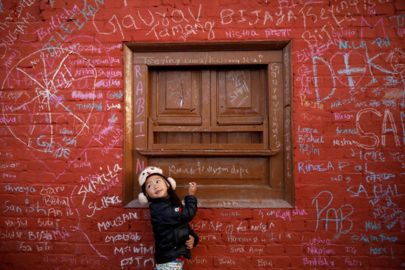 Девочка пишет на стене храма